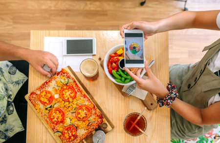 Top view of unrecognizable young girl taking video of fresh poke bowl salad with smartphone in a...