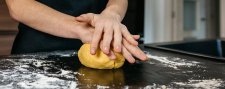 Banner of chef hands kneading fresh pasta dough on a dark, flour dusted kitchen counter, showcasing...