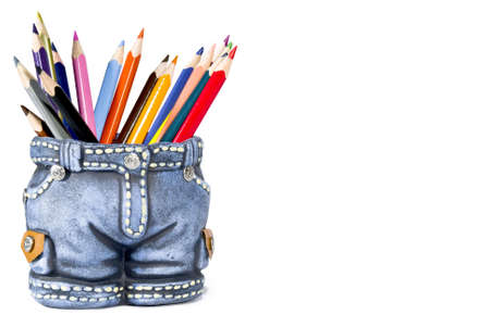 Set of color pencils in a ceramic vase isolated on white backgroundの写真素材