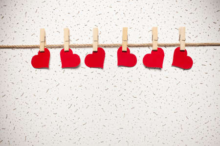 red hearts on a clothespin on a white wall