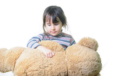 childhood, toys and people concept - cute little girl hugging teddy bearの写真素材