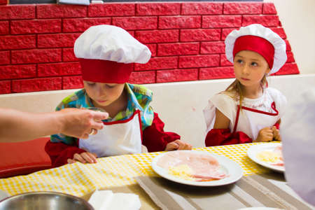 Alchevsk, Ukraine - July 23, 2017: School cook for children. Meat rolls with cheese are prepared.のeditorial素材