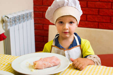 Alchevsk, Ukraine - July 23, 2017: School cook for children. Meat rolls with cheese are prepared.のeditorial素材