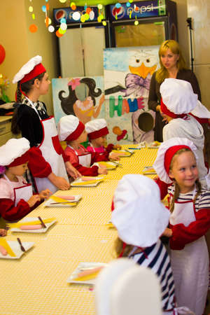 Alchevsk, Ukraine - July 30, 2017: School cooks for children. Learn to cook pasta with sausages -のeditorial素材