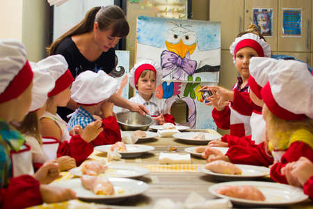 Alchevsk, Ukraine - July 23, 2017: School cook for children. Meat rolls with cheese are preparedのeditorial素材