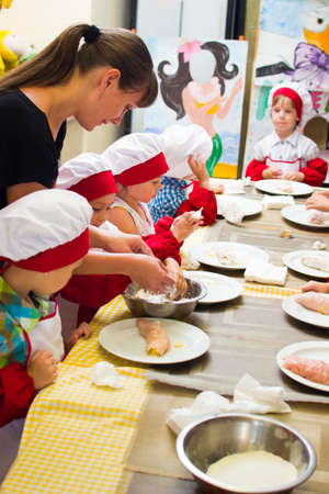 Alchevsk, Ukraine - July 23, 2017: School cook for children. Meat rolls with cheese are preparedのeditorial素材