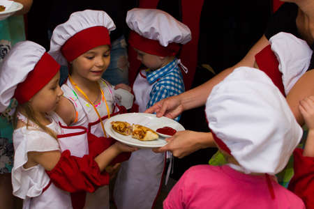 Alchevsk, Ukraine - July 23, 2017: School cook for children. Meat rolls with cheese are preparedのeditorial素材