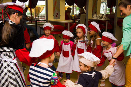 Alchevsk, Ukraine - July 30, 2017: School cooks for children. Learn to cook pasta with sausagesのeditorial素材