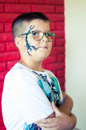 Alchevsk, Ukraine - August 3, 2017: A child draws a face for a children's party. Aqua makeup for...