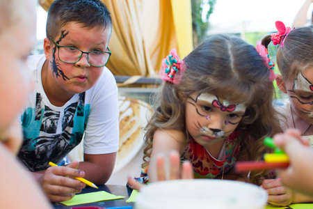 Alchevsk, Ukraine - August 3, 2017: A little boy and a girl are drawing at the table. View from above.のeditorial素材