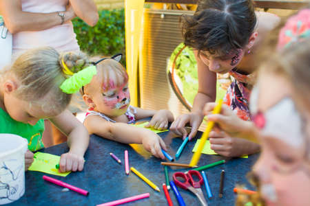 Alchevsk, Ukraine - August 3, 2017: A little boy and a girl are drawing at the table. View from above.のeditorial素材