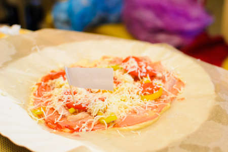 child preparing pizza on paper in the kitchen.の写真素材