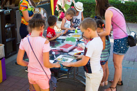 Alchevsk, Ukraine - July 27, 2017: Children paint with glue and colored sand. Children's party -のeditorial素材