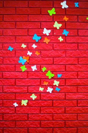 red brick wall with pasted paper butterfliesの写真素材