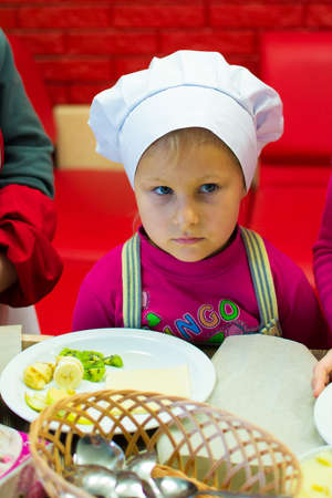 Alchevsk, Ukraine - October 15, 2017: school cooks for children in a cafe. preparing fruit pizza.のeditorial素材
