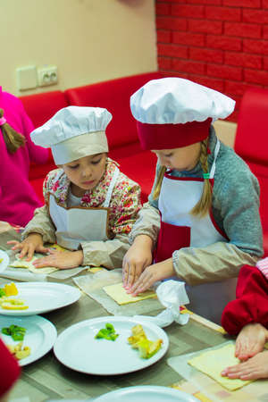Alchevsk, Ukraine - October 15, 2017: school cooks for children in a cafe. preparing fruit pizza.のeditorial素材