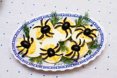 stuffed eggs decorated with olives in the form of spiders.の写真素材