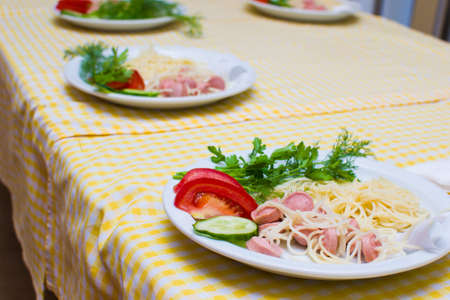 children learn to cook spaghetti in school cooks for small children.の写真素材