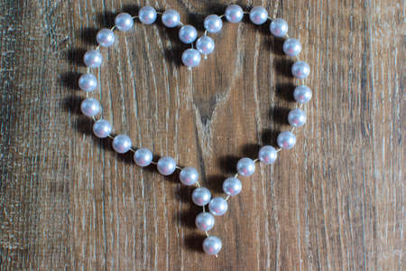 heart made of beads on a wooden background