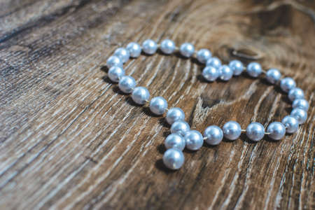 heart made of beads on a wooden backgroundの写真素材