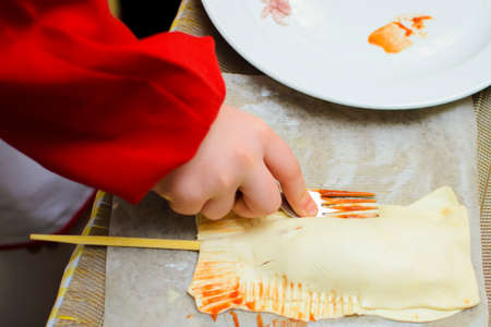 children prepare pies from bacon and cheeseの写真素材