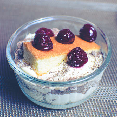 cream dessert in a bowl with cherriesの写真素材