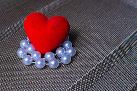 heart and beads on a textured substrate.の写真素材