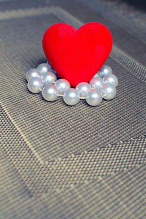 heart and beads on a textured substrate.の写真素材