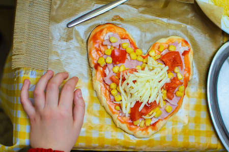 children cook pizza from raw ingredients with their own handsの写真素材