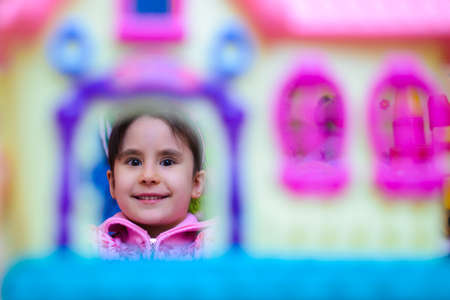 cute girl on the background of her toys smilingの写真素材