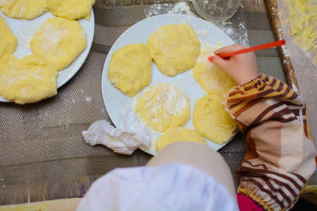 Children and chefs make dough on the table with their hands.の写真素材