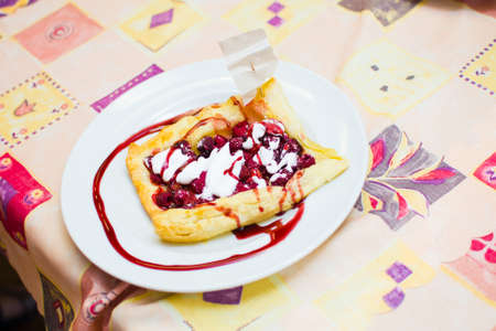 the child is preparing a pizza with berries. raspberry and strawberry.の写真素材