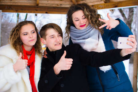 a group of friends do selfie in the winter in a clearing