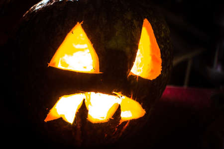 Scary Halloween pumpkin with glowing eyes and smile.