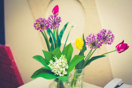Bouquet of wild flowers in a glass with blurred background.