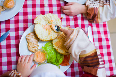 the child cooks a sandwich on his own from the ingredients.の写真素材