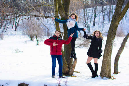 group of friends having fun in the park in winter near the river.の写真素材