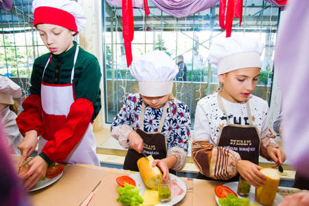 Alchevsk, Ukraine - November 8, 2018: children in the form of cooks prepare sandwiches.のeditorial素材