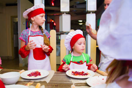 Alchevsk, Ukraine - November 8, 2018: children in the form of cooks prepare sandwiches.のeditorial素材