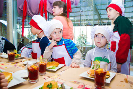 Alchevsk, Ukraine - November 8, 2018: children in the form of cooks prepare sandwiches.のeditorial素材