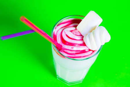 milkshake with a straw and marshmallows on a green background.の写真素材
