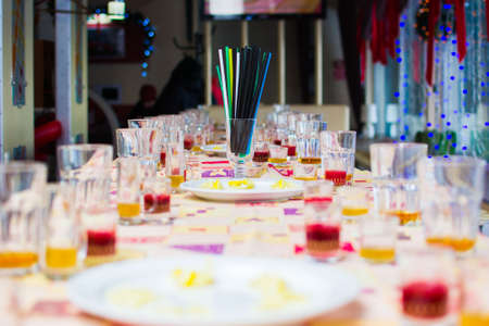 many tubules for a drink in a glass in the middle of the tableの写真素材