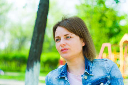 Summer woman portrait. Girl on a background of blurry childrens slides
