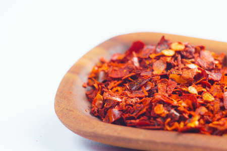 wooden shovel with seeds of red pepper on a white background.の写真素材