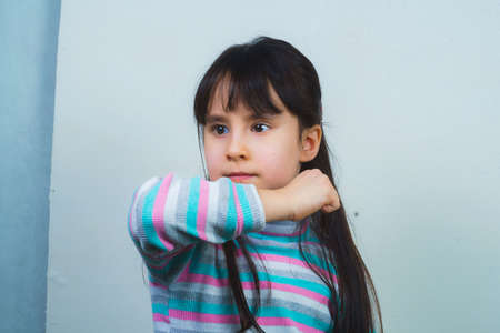 Portrait of a cheerful child with long hair and a striped sweater.の写真素材