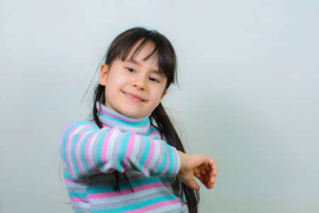 Cool budgie. A cute yellow budgerigar is sitting on the shoulder of a girl with long hair.の写真素材