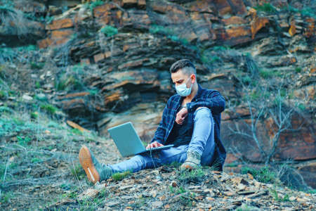 medical mask as protection against coronavirus. guy in the mountains isolated from coronavirus