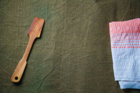 The wooden spatula lie on a green ragcloth next to the napkin.の写真素材