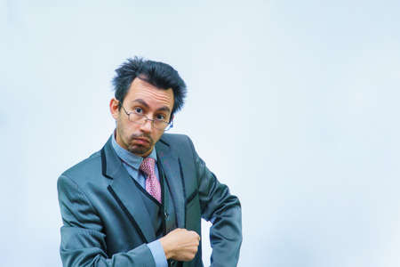 Funny unshaven man in suit with tie on gray backgroundの写真素材