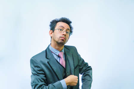 Funny unshaven man in suit with tie on gray backgroundの写真素材